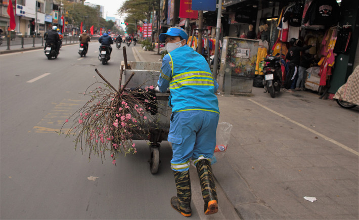 Hình ảnh công nhân thu gom rác tranh thủ dồn xe để có phương tiện đi thu gom trên đường phố Hà Nội.