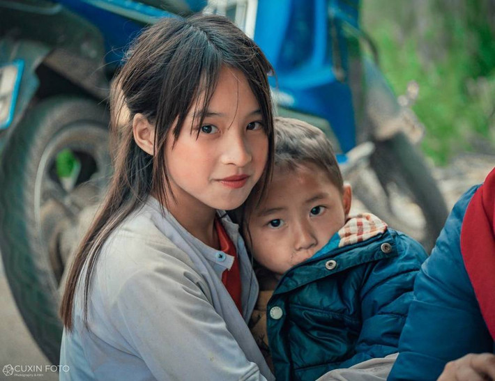 Theo đó, hình ảnh cô bé có làn da ngăm trong trang phục giản dị, trên tay đang bế một em bé trai khiến cho người xem phải "nao lòng". Đôi mắt đen huyền của em khiến cư dân mạng vô cùng ấn tượng.