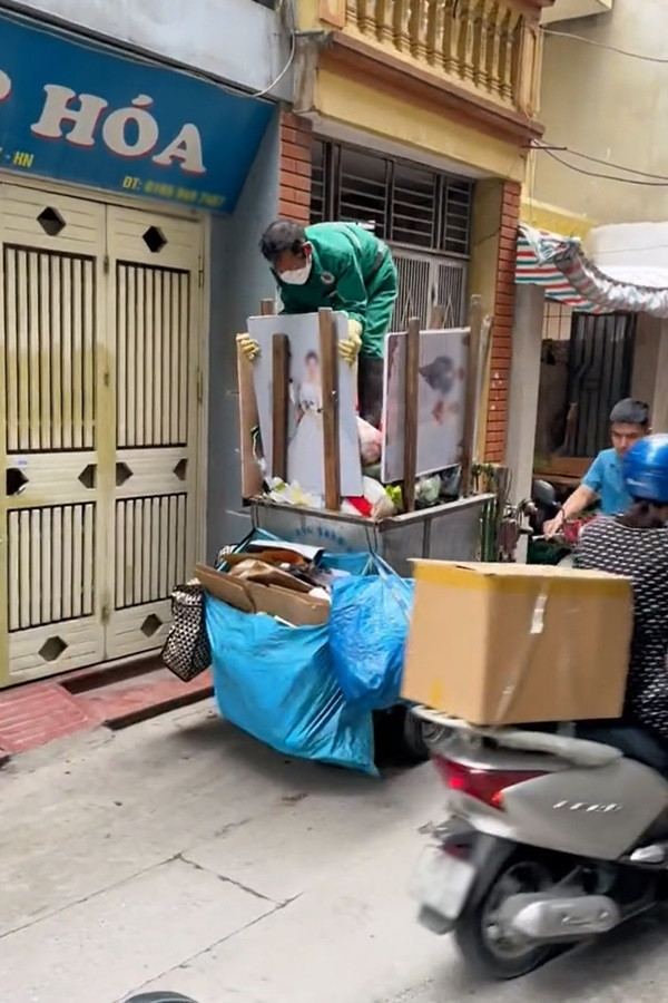 Theo hình ảnh ghi lại có thể thấy 2 tấm ảnh cưới treo tường vẫn còn khá mới. Có lẽ vì bị vứt bỏ nên chú gom rác đã thu lại, chất lên xe. Do kích thước lớn nên chú đành dựng nó lên, quay mặt trước ra ngoài rồi gác sang 2 bên để chỗ cho các loại rác thải khác.