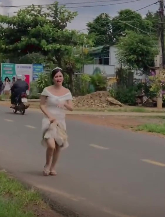 Ngay khi không thấy bạn đâu, cô dâu dù chưa thay chiếc váy nặng nề ra nhưng đã túm phần tà váy để đuổi theo xe.