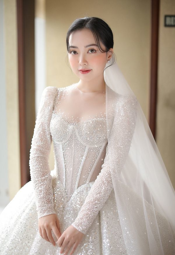Chiếc váy cưới của Mai Hà Trang được tạo nên trên nền vải trắng, bộ váy được dát nhũ ánh xà cừ và đính thêm 20 nghìn viên đá Swarovski khiến cho toàn bộ chiếc váy sáng lấp lánh.
