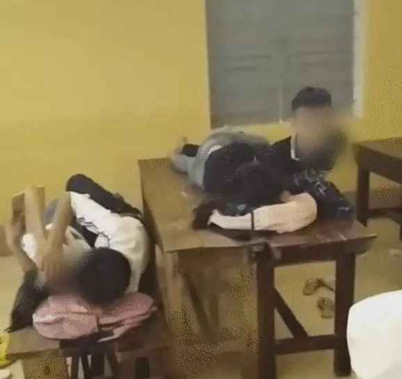 Hai cặp đôi tranh thủ giờ ra chơi nằm trên bàn ghế thể hiện tình cảm.