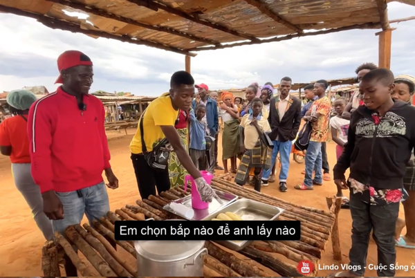 Lindo làm nhiệm vụ gói ngô cho khách, còn một anh chàng nữa thì hỗ trợ Youtuber rót nước ngô tặng mọi người.