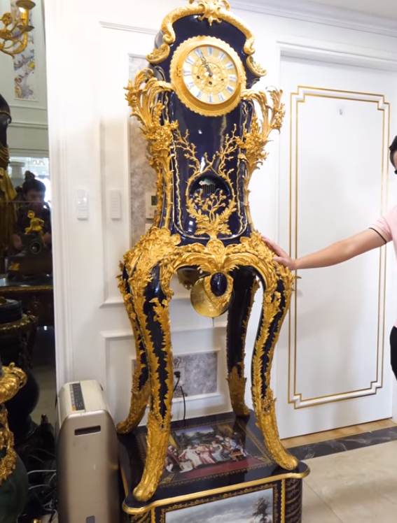 Trong phòng khách có chiếc đồng hồ bằng sứ, bên ngoài là đồng mạ vàng xuất xứ từ Đức.