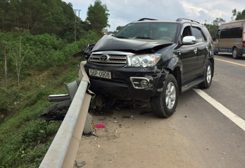 Chiếc Fortuner sau khi tông vào xe máy lao sang bên lề đường rồi đâm biến dạng một đoạn lan can. Chiếc xe máy nằm kẹt cứng dưới gầm xe ô tô Fortuner trong tình trạng hư hỏng rất nặng. Vụ tai nạn giao thông thương tâm khiến cả 2 mẹ con tử vong tại chỗ. Ảnh: Giao thông.