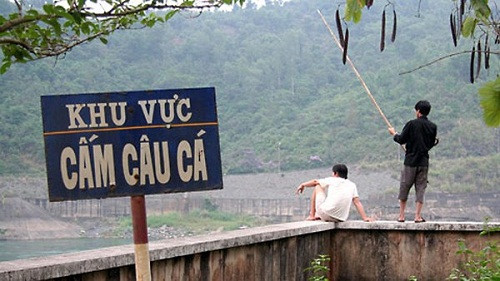 Ngay cạnh tấm biển cấm câu cá là những người hồn nhiên câu cá.
