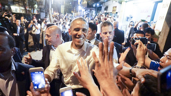 Trong chuyến thăm Việt Nam, ông Obama gây thiện cảm về sự gần gũi, cởi mở, hòa đồng với người dân. Ông đi ăn bún chả bình dân, vui vẻ chụp ảnh, bắt tay người hâm mộ. Ảnh: Dân Trí.