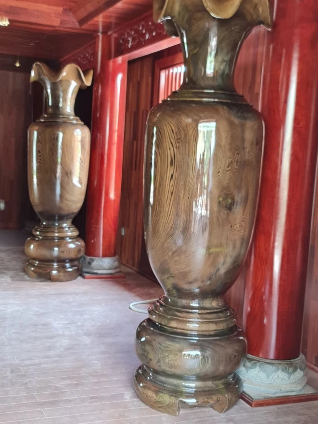 Bên trong căn nhà còn có bộ lục bình bằng gỗ cẩm vàng, bộ bàn ghế bằng gỗ hương được chạm trổ tỉ mỉ và công phu. Ảnh chụp màn hình NhaTo