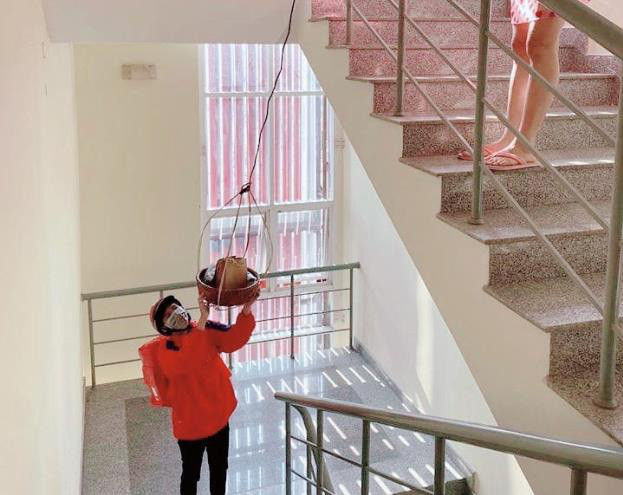 Với tuyệt chiêu này, khách ở tầng 2, tầng 3 của tòa nhà cũng có thể nhận hàng mà không cần xuống tận nơi. Ảnh: Dân Việt