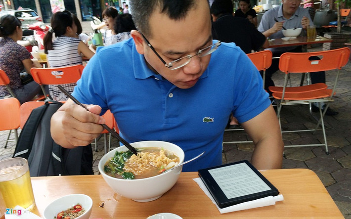 Tay gắp thức ăn, mắt nhìn công nghệ.