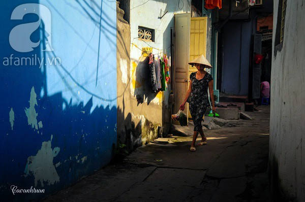 Một phụ nữ đi chợ về trên con ngõ vắng.