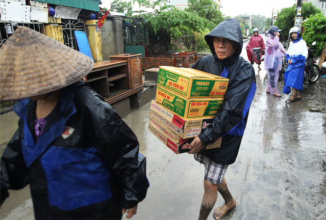 Một người đàn ông ôm lấy những thùng mì tôm để chống đói. Nước lũ dâng cao khiến điện mất, nước sạch tạm thời bị cắt khiến cho việc sinh hoạt của người dân gặp rất nhiều khó khăn.