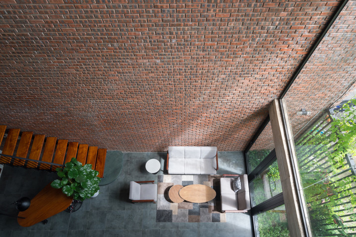 Mảng tường gạch vững chắc tạo thành khối lớn khiến ngôi nhà nhìn giống một vùng lãnh thổ riêng.