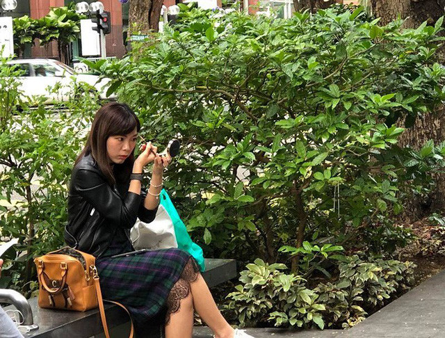 Một bạn gái tranh thủ trang điểm trong lúc chờ mua iPhone X. Ảnh: Facebook Xì Trum 8.