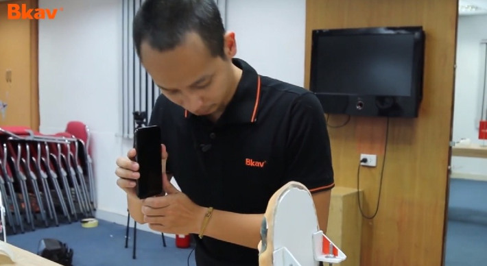 Chiếc iPhone X được đăng ký Face ID khuôn mặt chủ nhân, ngay sau đó đưa ra trước mặt chiếc mặt nạ mới. Ảnh: Bkav.