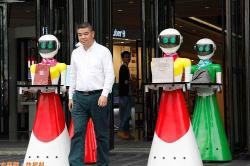 Một người đàn ông giàu có ở Quảng Đông (Trung Quốc) còn tuyển 8 em robot đi theo để phục vụ. Ảnh: Xinhua.