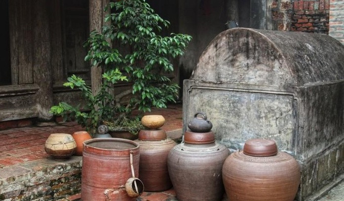 Trước hiên nhà là những chiếc chum lớn ngày xưa nó được dùng để đựng tương. Trải qua bao năm tháng, những chiếc chum vẫn còn nguyên, không sứt mẻ. Ảnh: Lao động thủ đô