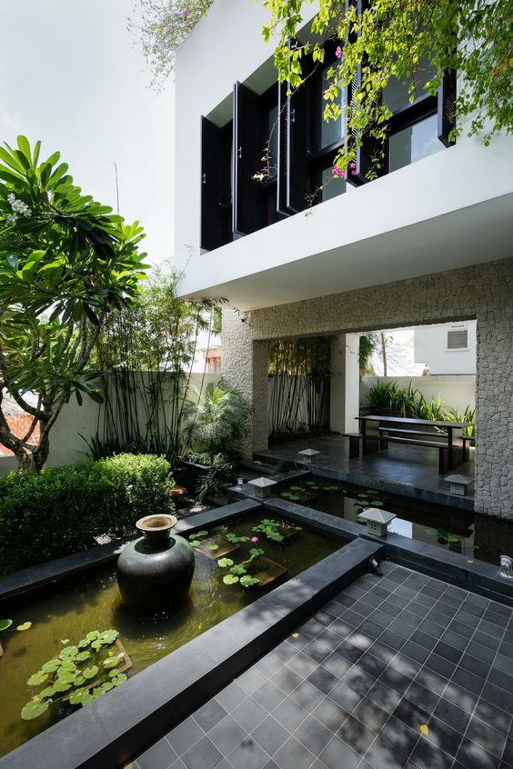 Để tạo sự mát mẻ và sống động cho khu vườn, nên chọn cây bụi lớn và kết hợp các loại cây thủy sinh cùng cá cảnh. Nguồn ảnh: Houzz.