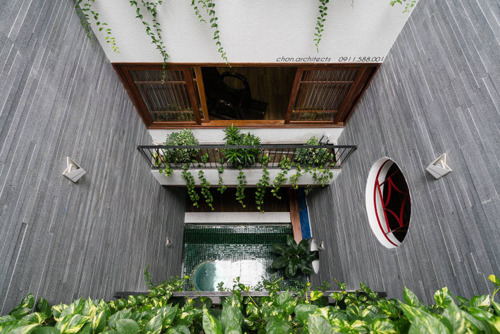 Hồ nước giữa nhà lấp lánh dưới ánh nắng mặt trời, giúp phản chiếu ánh sáng lên mảng tường đá.