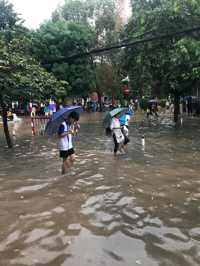 Những cơn mưa lớn kéo dài khiến cuộc sống của người dân Thủ đô bị đảo lộn. (Ảnh: PV/Vietnam+)