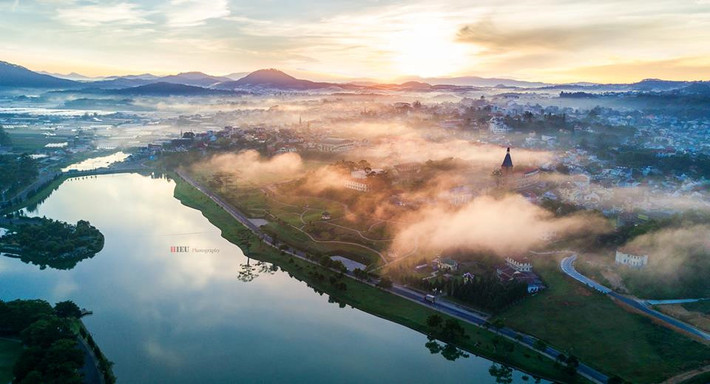 Sau giấc ngủ dài của một đêm lạnh, cả thành phố dịu dàng đón chào ngày mới bằng một không gian xanh mướt, lãng đãng từng lớp sương mỏng mảnh hòa với mây trắng bồng bềnh.
