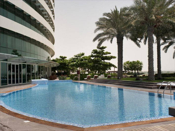 Bể bơi trong xanh bên ngoài khách sạn 5 sao. Ảnh: Booking.