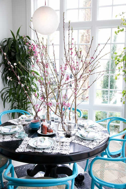 Để trang trí bàn ăn với phong cách lãng mạn, bạn có thể sử dụng nhiều lọ thủy tinh nhỏ và cắm các cành đào cao. Ảnh: Kenhphunu.