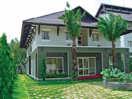 Mẫu nhà 2 tầng mái thái có sân rộng và không gian xanh tươi nổi bật. Ảnh: Nhabinhduong.