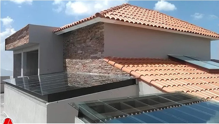 Thiết kế mái nhà theo phong cách mộc mạc với tường gạch thô và mái ngói hồng cam. Ảnh: Arkisav.