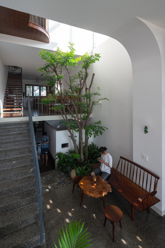 Phòng khách bố trí ở tầng trệt nằm phía trước sân đầy cây và ánh sáng.