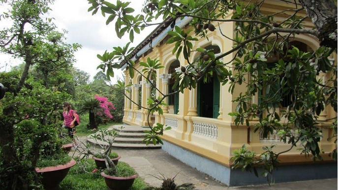 Dọc hai bên lối vào nhà là vườn cỏ xanh và sân vườn rộng lớn, nhiều loại cây ăn quả, loại hoa đẹp như lan, sứ... Ảnh: Hải Yến.