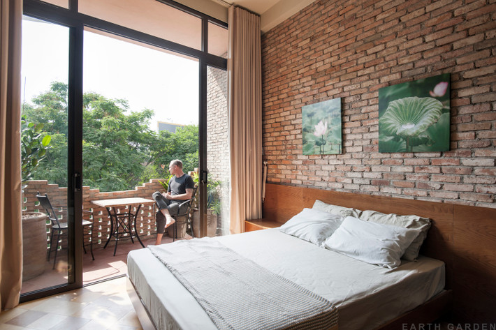 Phòng ngủ mộc mạc với thiết kế gạch trần.