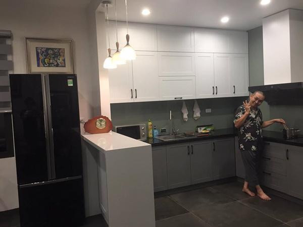 Căn bếp rộng rãi được nghệ sĩ bố trí ngăn nắp với tông màu trắng xám chủ đạo.