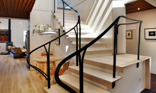 Tay vịn được cách điệu bằng những đường uốn lượn uyển chuyển tạo sự thanh thoát, mềm mại cho cầu thang. Ảnh: Tuvansango.