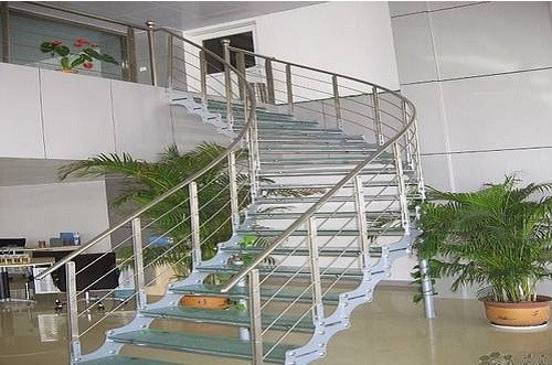 Cầu thang inox kết hợp kính cường lợp có thể uốn lượn theo vòng cung đầy thẩm mỹ. Ảnh: Thietkenhadepmoi.