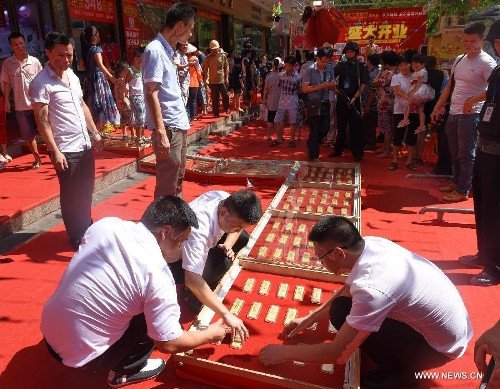 Nhân dịp khai trương, một tiệm vàng ở Quỳnh Hải, tỉnh Hải Nam, Trung Quốc gây bất ngờ khi trải gần 30 kg vàng lót đường tiếp đón khách. Ảnh: News.