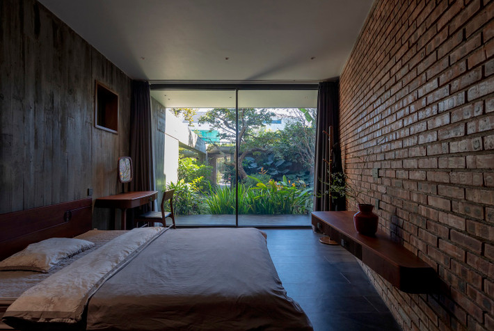 Kiến trúc của tầng 2 được gói gọn trong một khối vuông vắn nằm 2 bên là tường gạch rào kết hợp với kết cấu thông tầng tạo cảm giác toàn bộ tầng 1 là một khu vườn với một thể thống nhất.