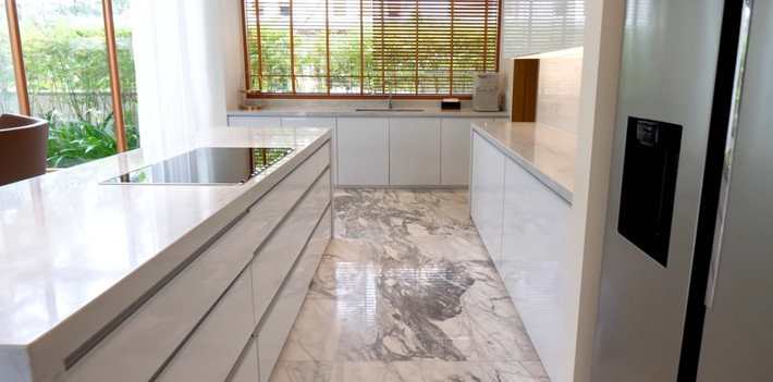 Khu bếp ốp đá marble trắng vân mây từ mặt bàn bếp đến sàn nhà.