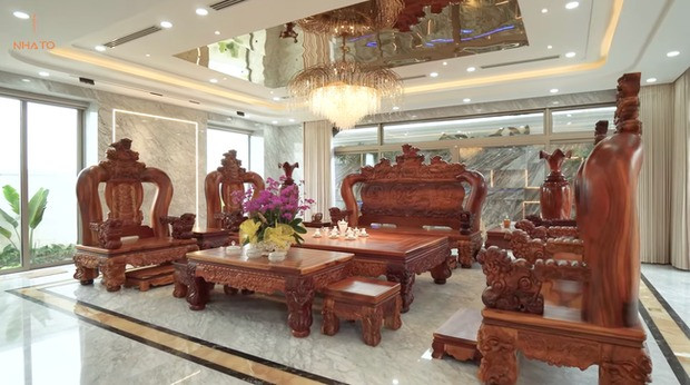 Điểm nhấn trong phòng khách là bộ bàn ghế gỗ hương nguyên khối, cũng thuộc dạng hiếm thấy.