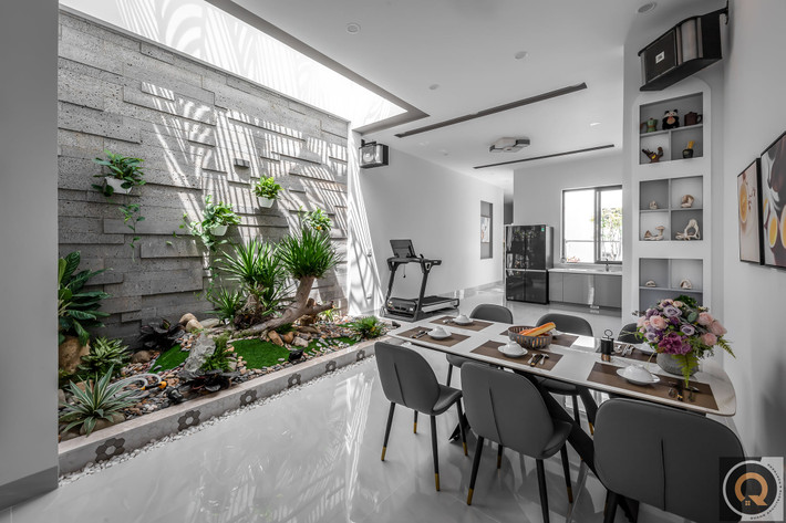 Bàn ăn hiện đại được bố trí cạnh giếng trời.