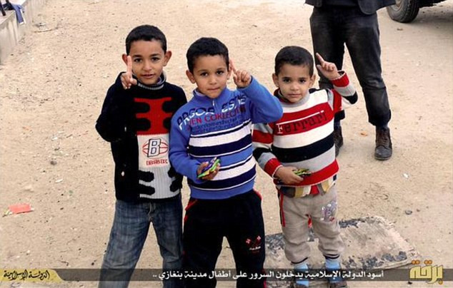 Binh lính IS tặng kẹo cho những đứa trẻ ở thành phố Benghazi, Libya. Đây là một mánh khóe để thu hút những "học viên" nhỏ tuổi hơn.