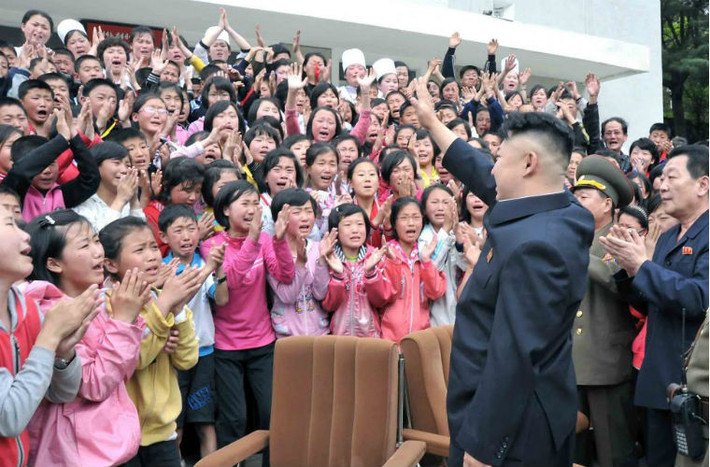 Ông Kim Jong-un vẫy tay chào các em học sinh trong chuyến thăm Trại trẻ Myohyangsan ngày 20/5/2013.