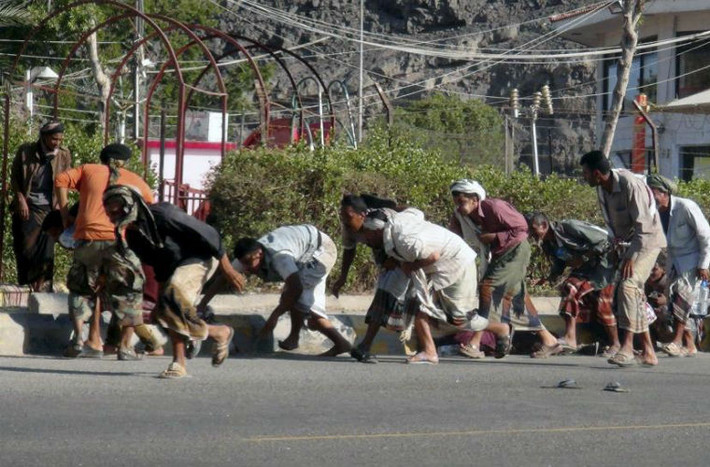 Người dân nháo nhác tìm nơi trú ẩn khi tiếng súng vang lên tại căn cứ quân sự ở thành phố Aden, Yemen ngày 25/3.