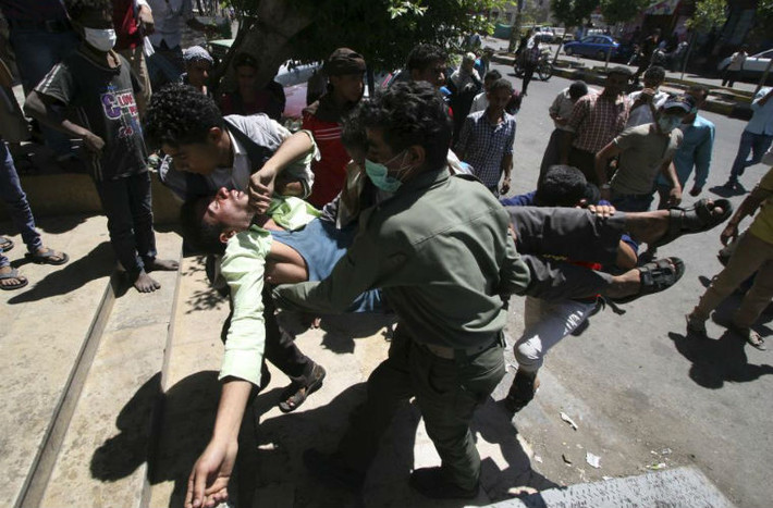 Những người biểu tình chống phiến quân Houthi đang chuyển một người bị thương sau khi cảnh sát nổ súng giải tán đám đông tại thành phố Taiz, ngày 25/3.