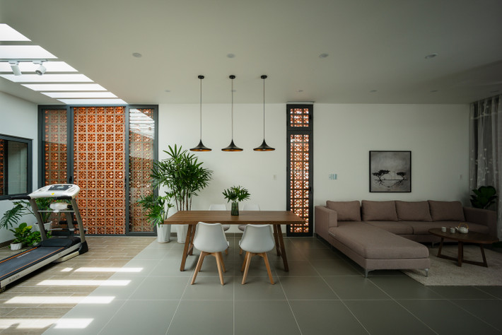 Gạch thông gió đất nung, màu gỗ trầm trên nền sơn trắng kết hợp mảng xanh tạo nên nét hiện đại pha chút mộc mạc hòa mình vào thiên nhiên.