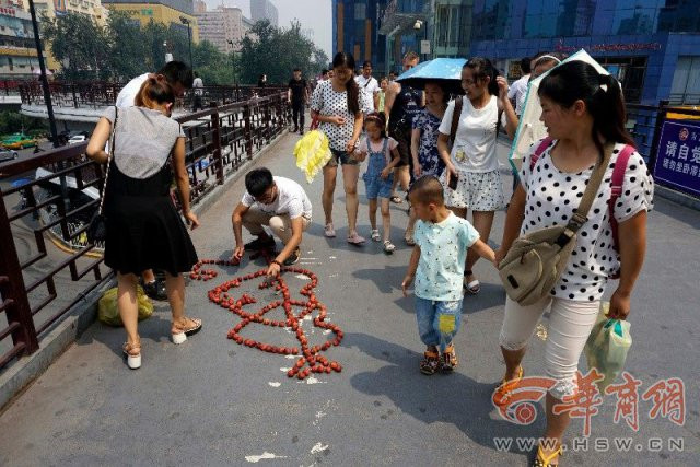 Chàng trai tên Dong cùng với một số người bạn thân xếp từng quả vải tạo thành hình hai trái tim với mũi tên ở giữa và chữ “Love” trên một cây cầu dành cho người đi bộ ở thành phố Tây An, Trung Quốc. Việc làm của họ đã thu hút sự chú ý của những người qua đường.
