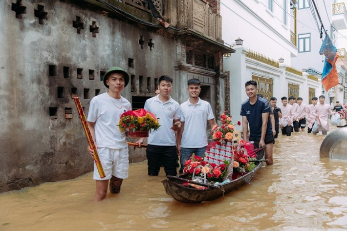 Đoạn đường lội nước vào nhà gái khá xa nên dàn phù rể cũng phải dùng xuồng nhỏ chở tráp cưới. Các quan khách người ôm váy, người xắn quần vượt đoạn đường ngập tiến vào nhà gái.