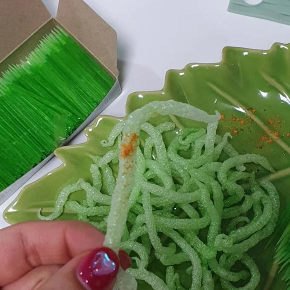 Sau khi đã được chiên phồng và vớt ra khỏi chảo, những chiếc tăm sẽ được rắc lên bột phô mai và các loại gia vị khác rồi thưởng thức.
