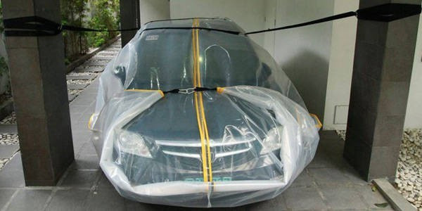 Bọc ô tô và chằng buộc trước khi bão đổ bộ.