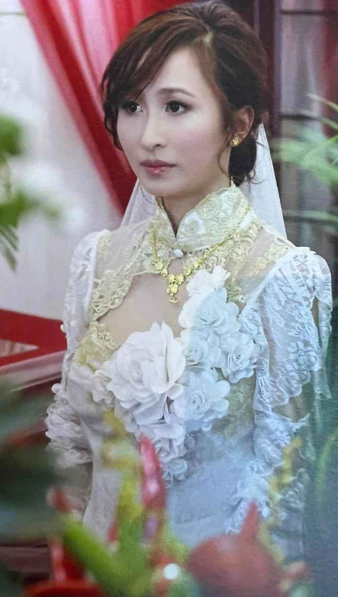 Mina Phạm mặc áo dài cách điệu, đeo một ít quà cưới là dây chuyền và lắc vàng, được chồng tặng nhẫn cưới kim cương.